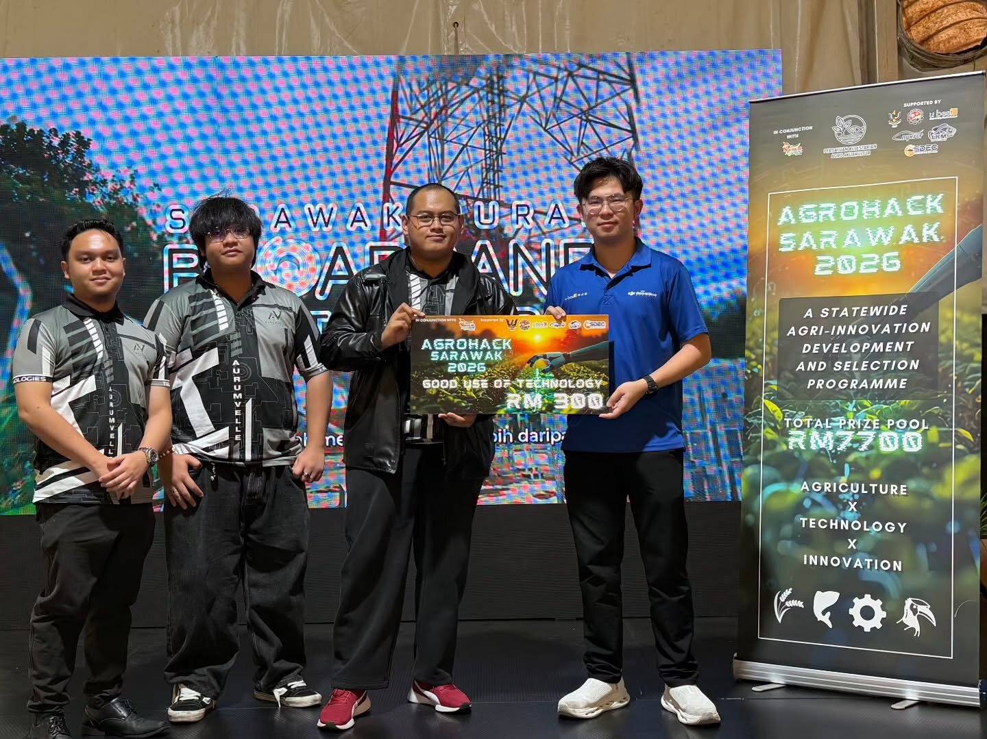 Aurumvelle team in company jerseys receiving the AgroHack Sarawak 2026 Good Use of Technology award on stage