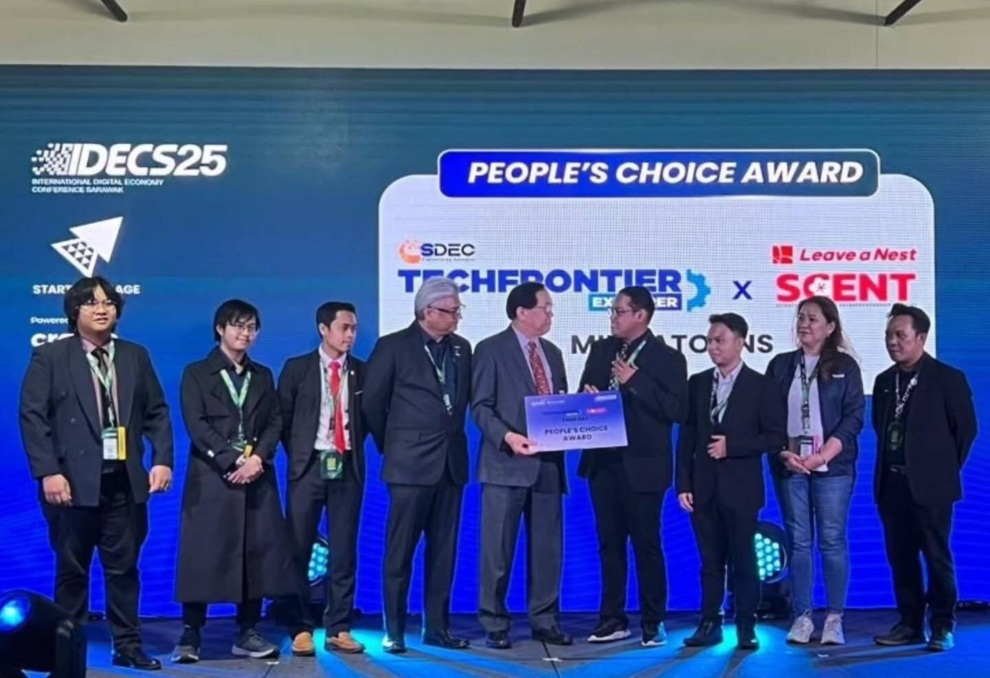 TheRookies on the IDECS25 stage receiving the People's Choice Award at the TechFrontier Explorer × SCENT Demo Day, with MindaToons on the screen