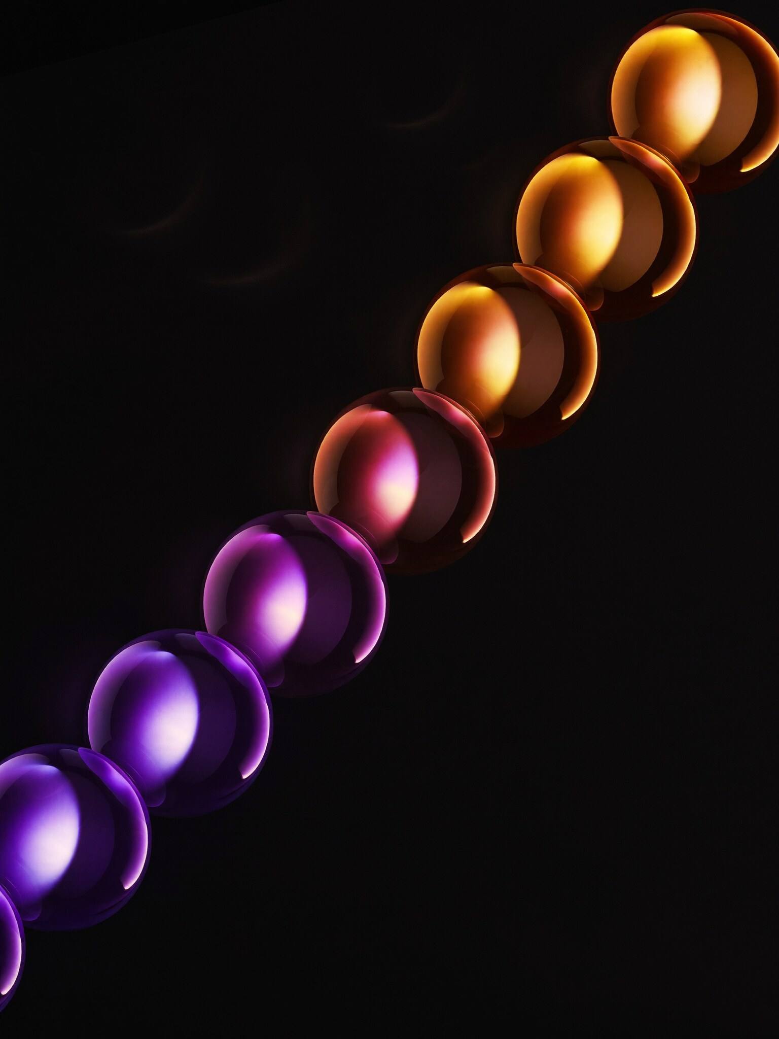 A chain of glass spheres flowing from violet to gold
